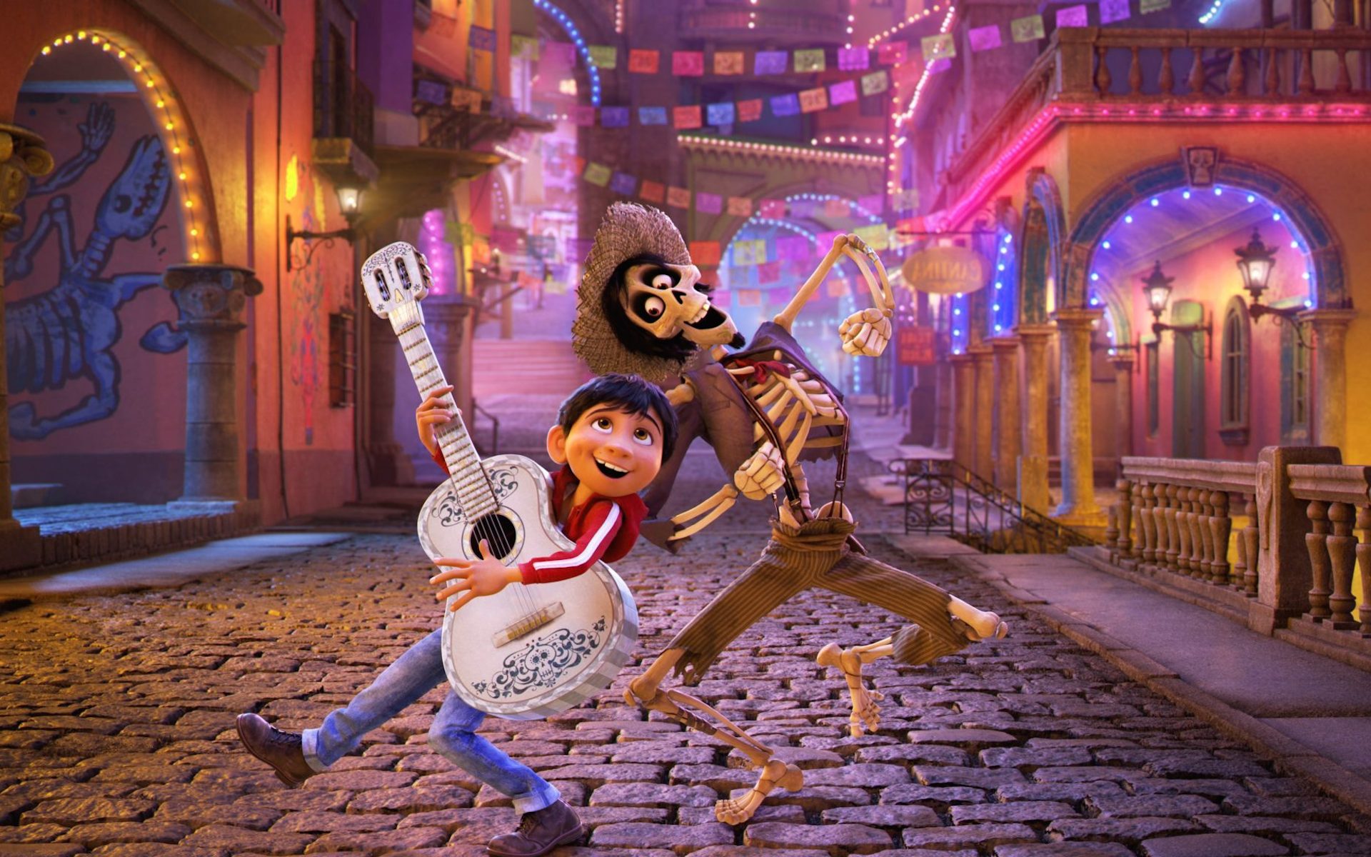 A still from the movie Coco shows a child dancing with skeletons.