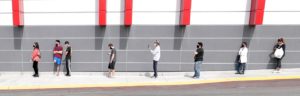 An illustration of people standing in a line socially distanced apart.