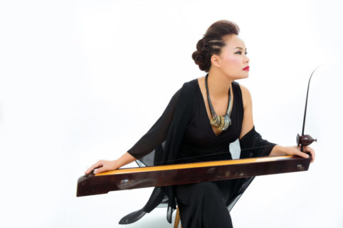 Vân-Ánh Võ holds the 16-string đàn tranh (zither) instrument.