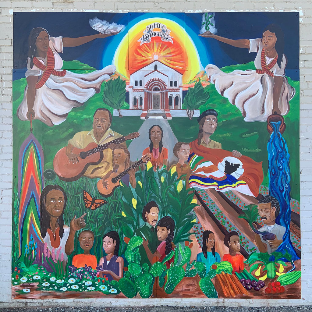 A bright and colorful mural depicting multiple persons engaged in activities such as playing the guitar and sitting in a garden.