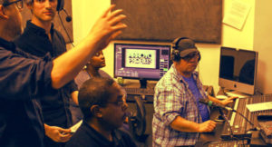 A group of persons in a recording studio.