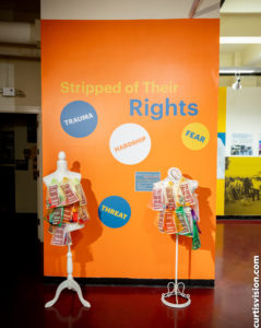 Two mannequin torsos with fabric are placed in front of a wall that reads, "Swiped of their rights."