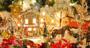 A winter scene with snow, lights, plants, and a horse.