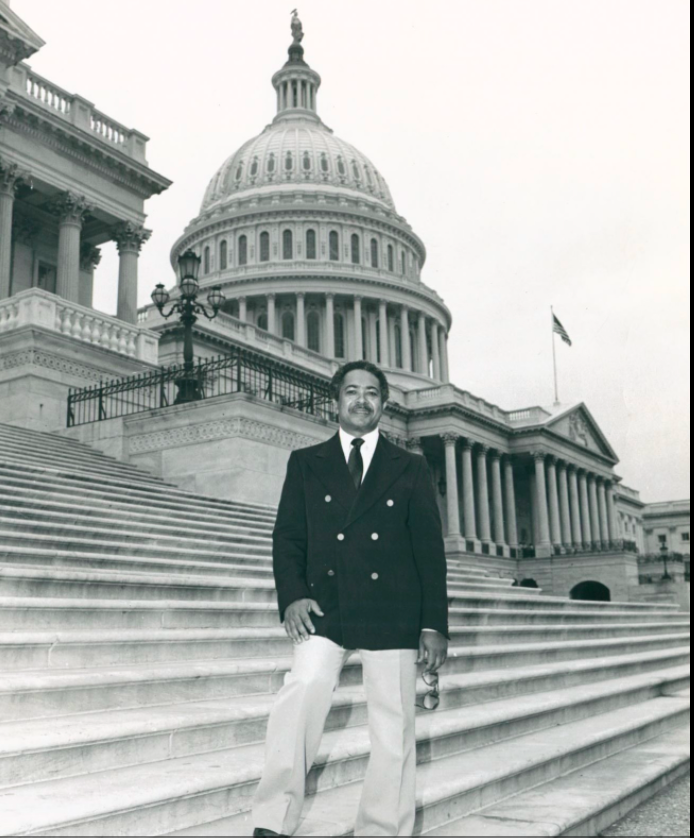 Mervyn M. Dymally stands in front of the capitol building in Washington DC.