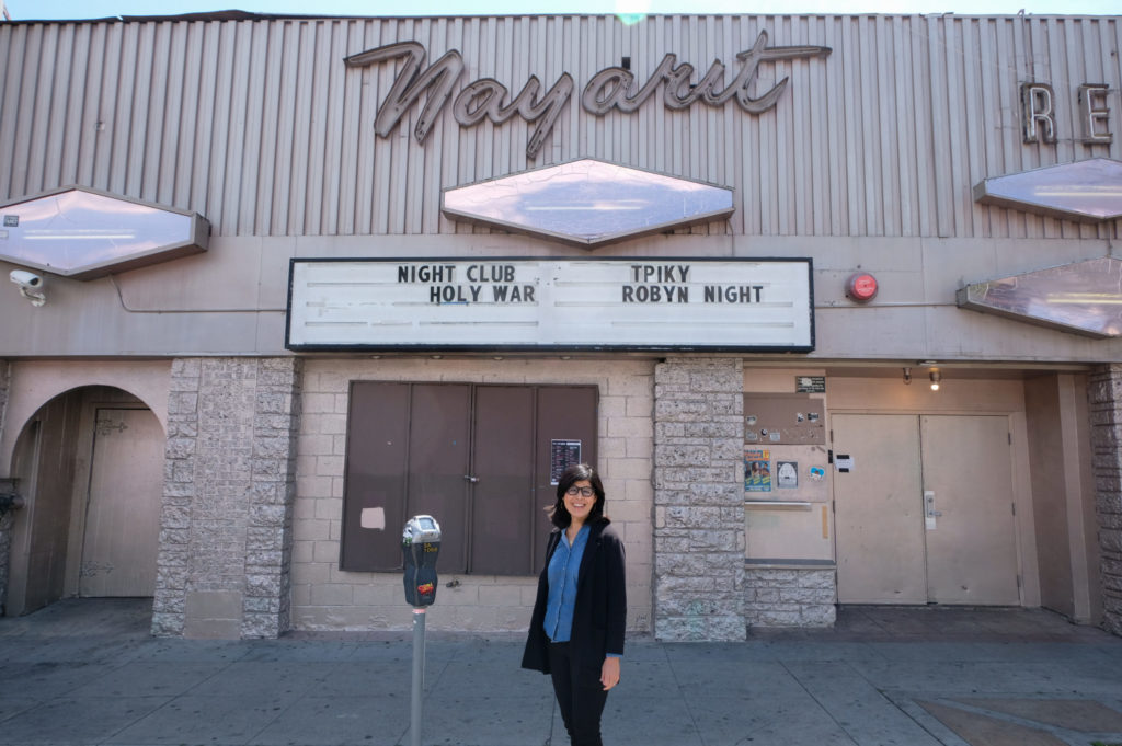 Natalia Molina stands in front of a nightclub.