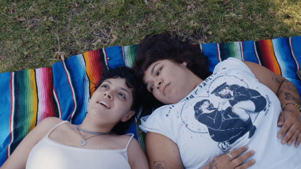 two people on a blanket in grass