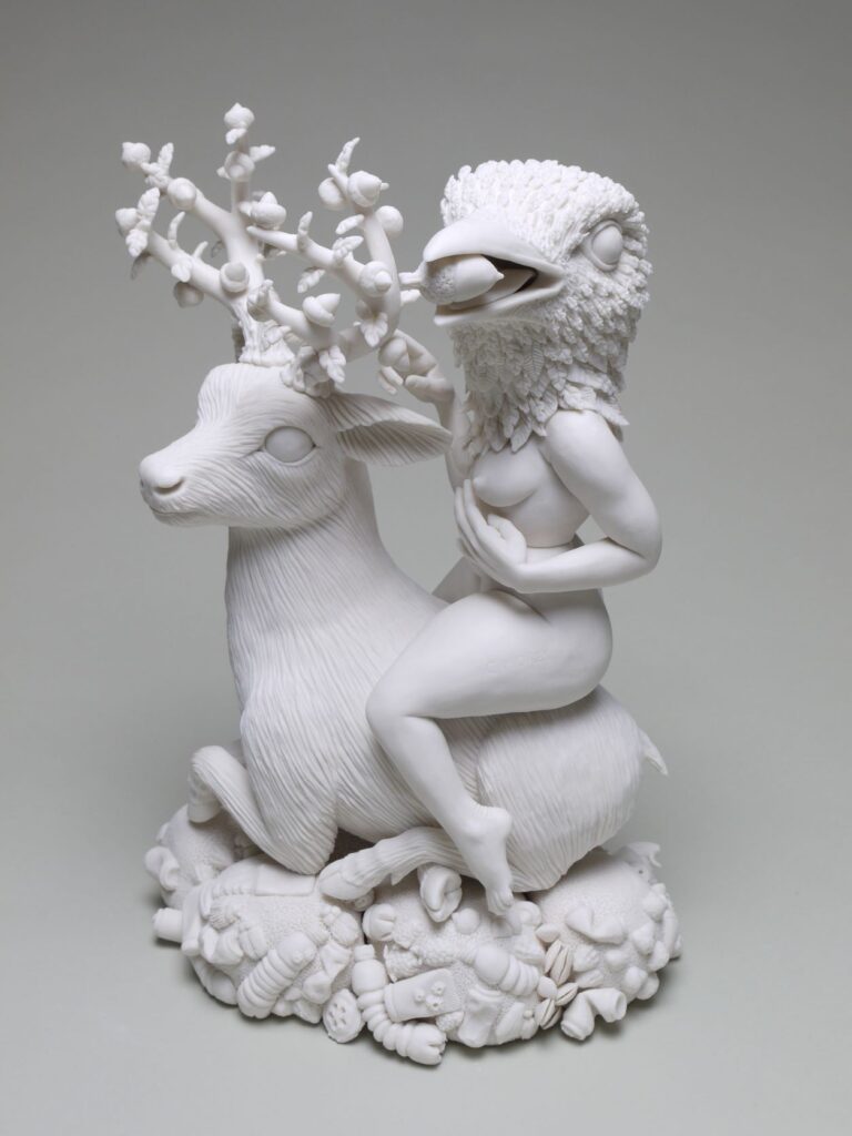 Clay sculpture featuring a  women with the head of a bird sitting atop a deer-like figure
