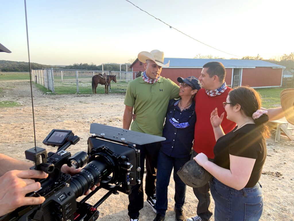 Four people stand on a farm, with vilm camera in the foreground.