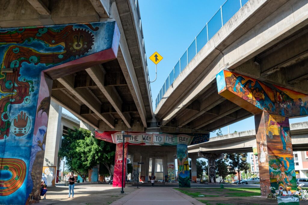 Colorful murals adorning the underside of a freeway intersection
