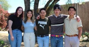 Five students pose for a photo outside.