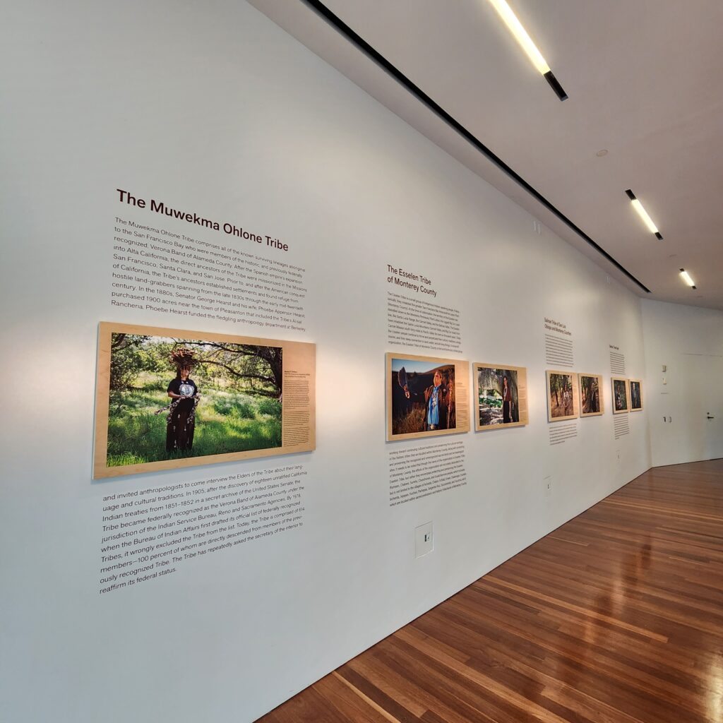 Museum gallery wall with portrait photographs and text