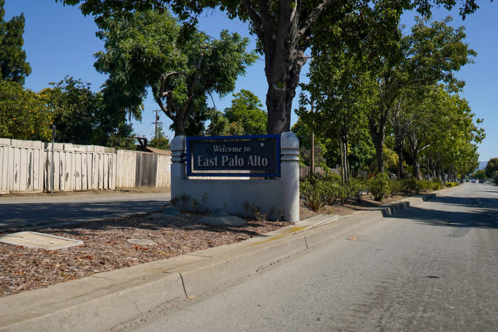 Street with city sign for Welcome to East Palo Alto.