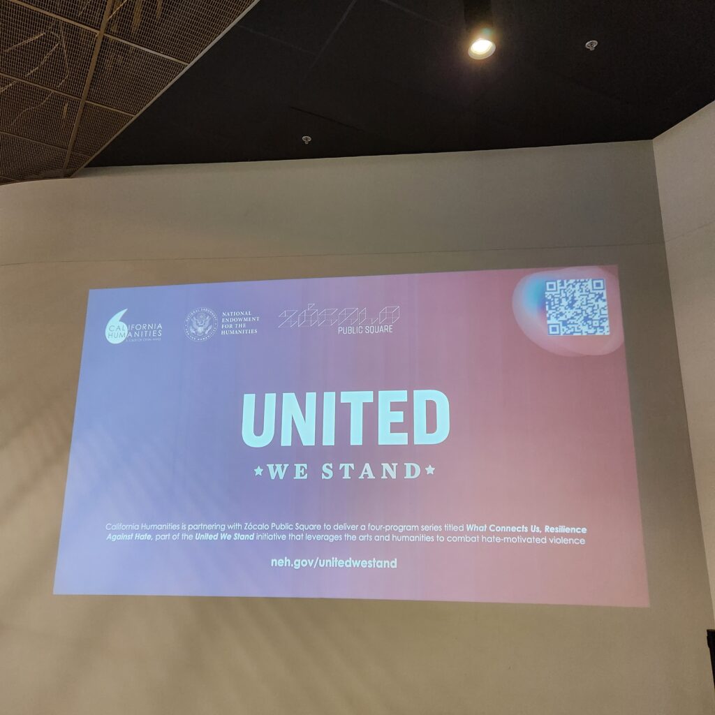 Projection of a slide on a white wall, with words United We Stand