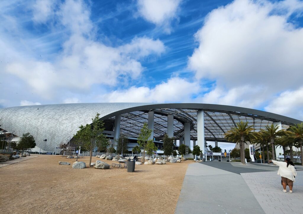 Exterior of a large stadium with curved metal wave design