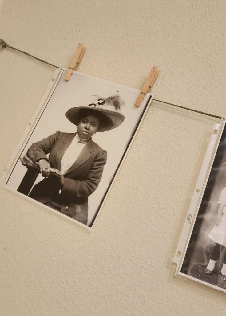 Black and white photo hung with a clothes pin on a line inside a museum gallery. Photo features a Black woman in formal dress, in black and white. Yuba Sutter Black History_historic photos_June 25_24