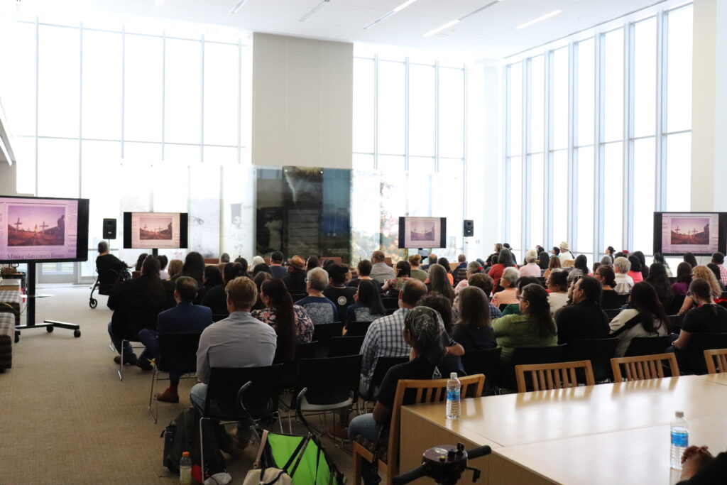 A room full of people seated for a public program.